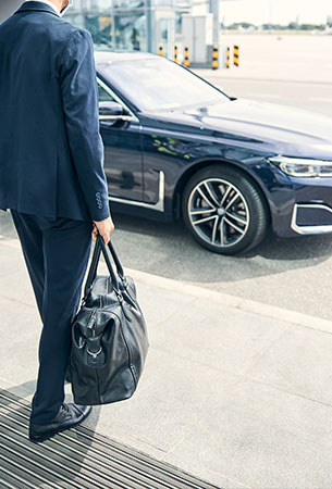 Professional chauffeur pickup with luxury sedan and luggage