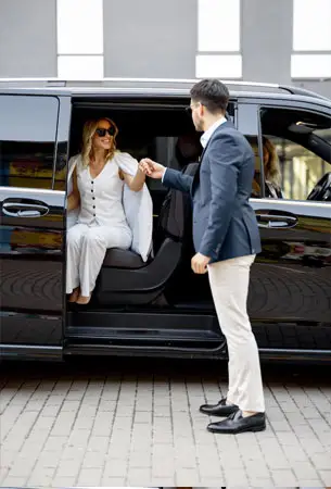 Professional Apollo Regional Transport chauffeur assisting a client into a luxury vehicle for a private transfer.